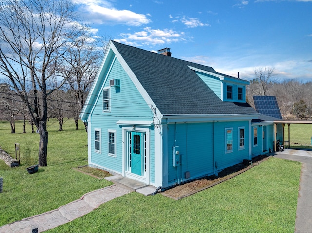 view of property exterior with a lawn, solar panels, a chimney, and roof with shingles