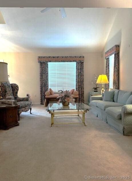 carpeted living room with lofted ceiling and a ceiling fan