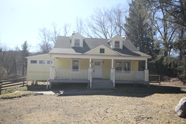 view of front of home featuring a porch, fence, and roof with shingles