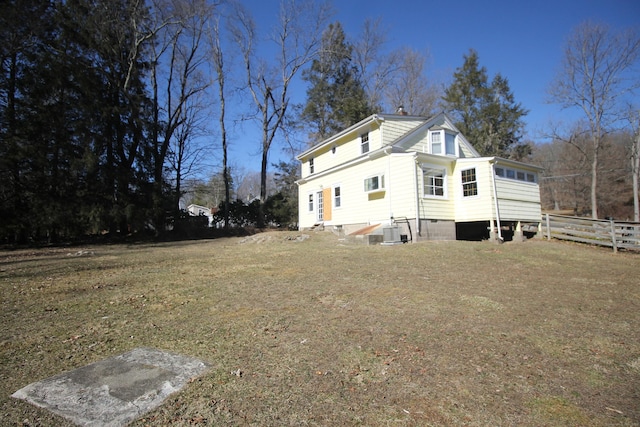 view of side of home featuring central AC and fence