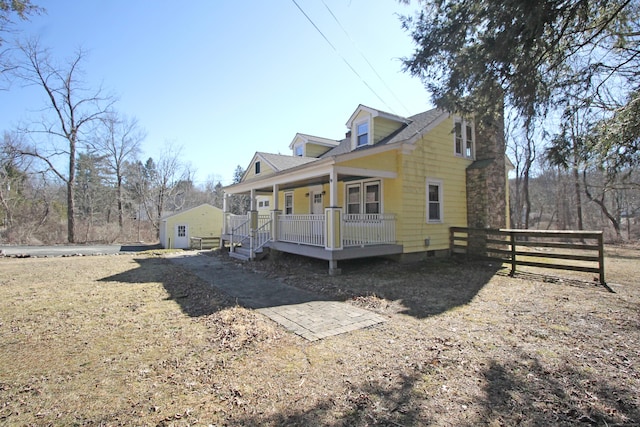 view of side of home with a porch and fence