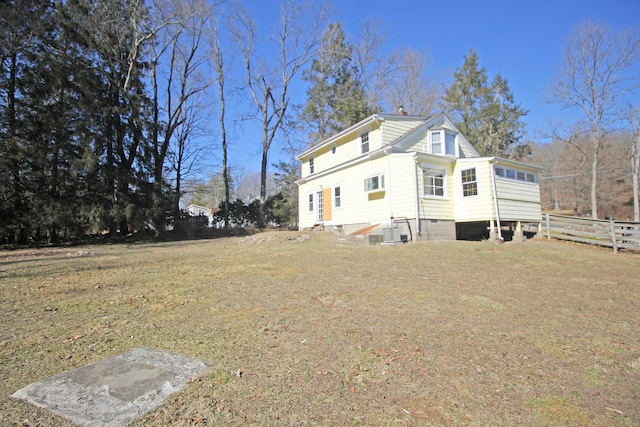 back of house featuring a yard, central AC unit, and fence