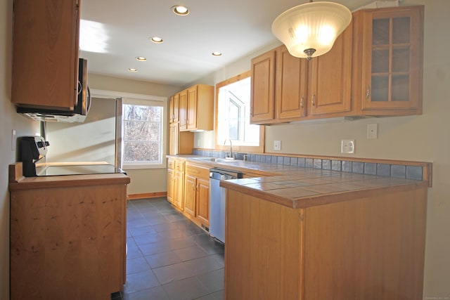 kitchen featuring glass insert cabinets, dishwasher, recessed lighting, stove, and a sink