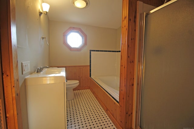 full bathroom with a shower with shower door, a wainscoted wall, toilet, a tub, and vanity