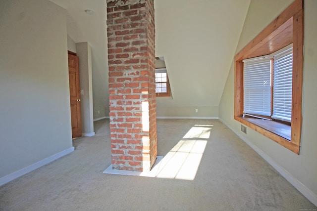 carpeted empty room with vaulted ceiling, visible vents, and baseboards