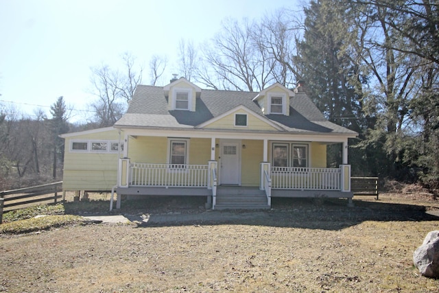 view of front facade featuring a porch, roof with shingles, and fence