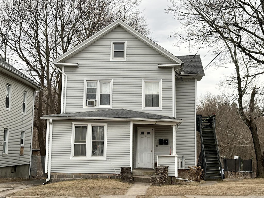 view of front facade with a shingled roof and a trampoline