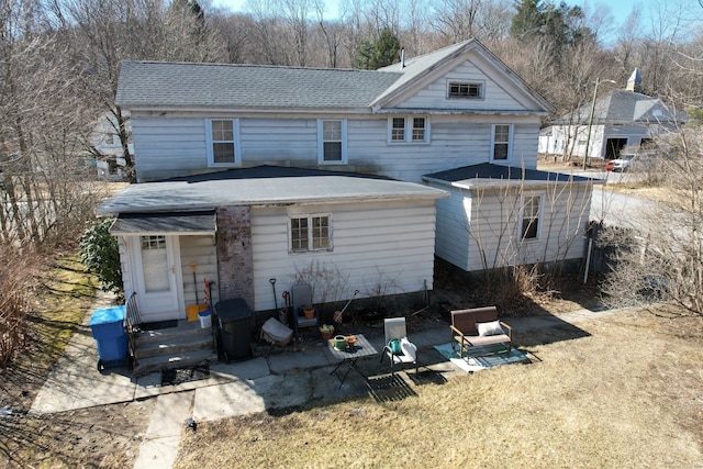 back of property with a shingled roof