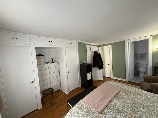 bedroom with dark wood finished floors and ensuite bath