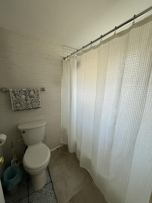 bathroom with curtained shower and toilet