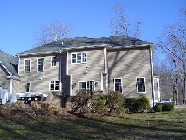 back of house with a lawn