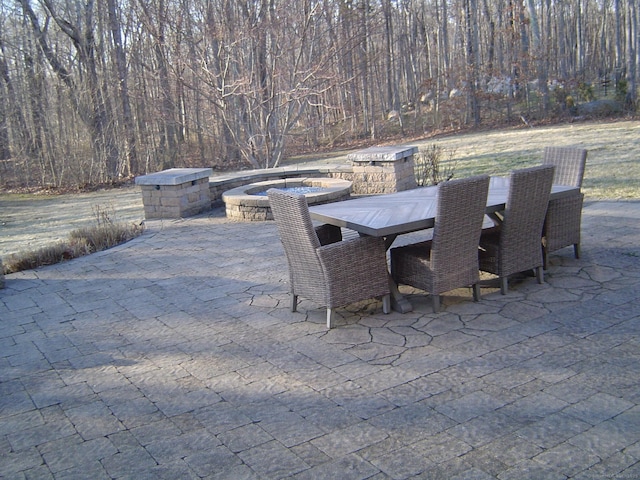 view of patio / terrace with outdoor dining space and a wooded view