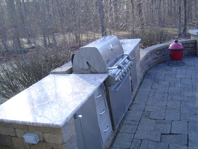 view of patio / terrace with grilling area, a view of trees, and area for grilling