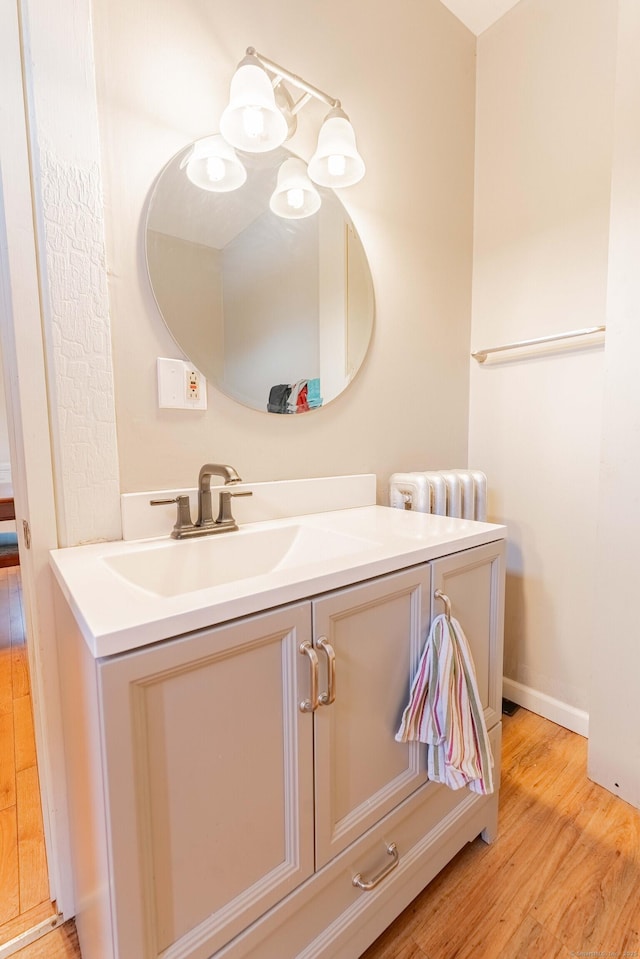 bathroom with baseboards, wood finished floors, and vanity