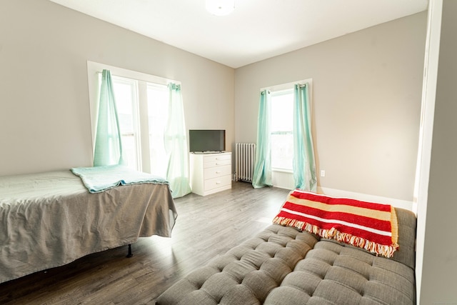 bedroom with wood finished floors and radiator heating unit