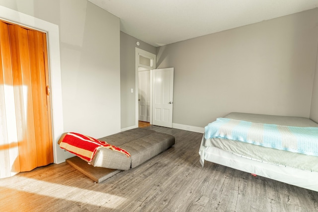 bedroom with baseboards and wood finished floors