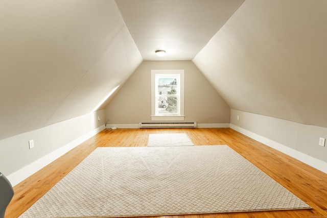 bonus room featuring baseboards, a baseboard heating unit, lofted ceiling, and wood finished floors