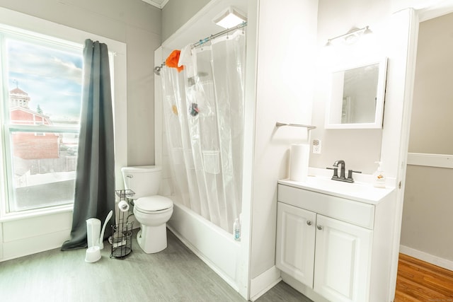 bathroom featuring baseboards, toilet, wood finished floors, shower / bath combination with curtain, and vanity