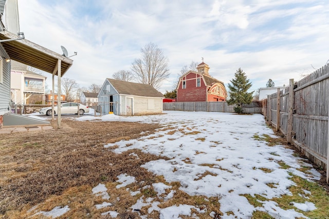 yard covered in snow with an outbuilding and a fenced backyard