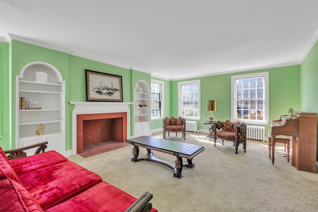 carpeted living room with a brick fireplace, radiator heating unit, and built in shelves