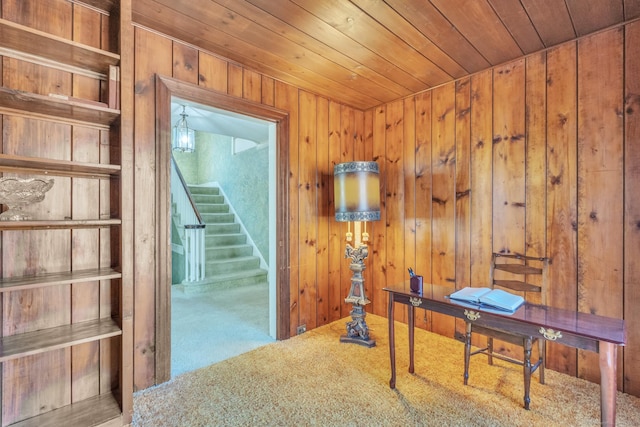 carpeted home office featuring wooden walls and wooden ceiling