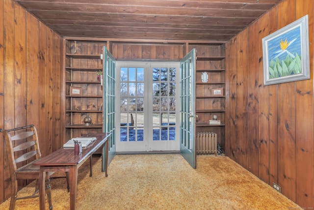 interior space featuring built in features, wooden walls, wood ceiling, and radiator heating unit