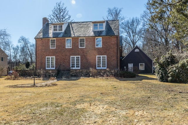 exterior space with french doors, a yard, a chimney, and brick siding