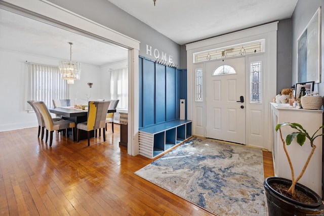 entryway with a wealth of natural light, a chandelier, baseboards, and hardwood / wood-style flooring