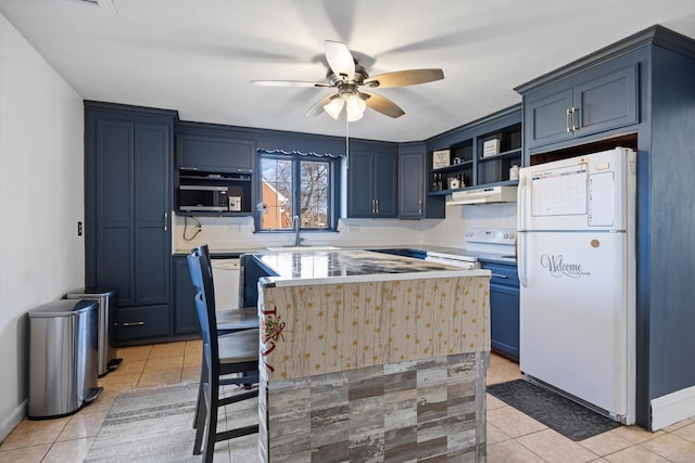 kitchen featuring open shelves, light tile patterned floors, white appliances, blue cabinets, and a sink