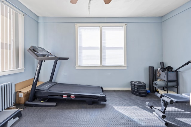 exercise area with baseboards, radiator heating unit, and ceiling fan