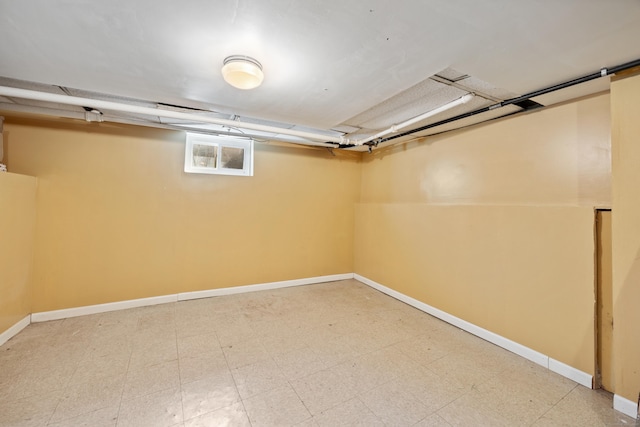 below grade area featuring light floors and baseboards