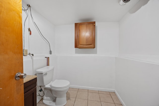 bathroom with tile patterned flooring, toilet, and baseboards