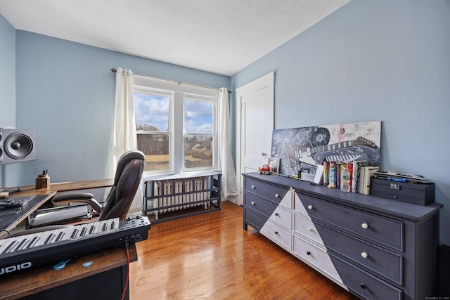 home office featuring light wood-style flooring and radiator