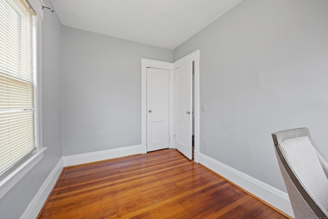 empty room with baseboards and wood finished floors