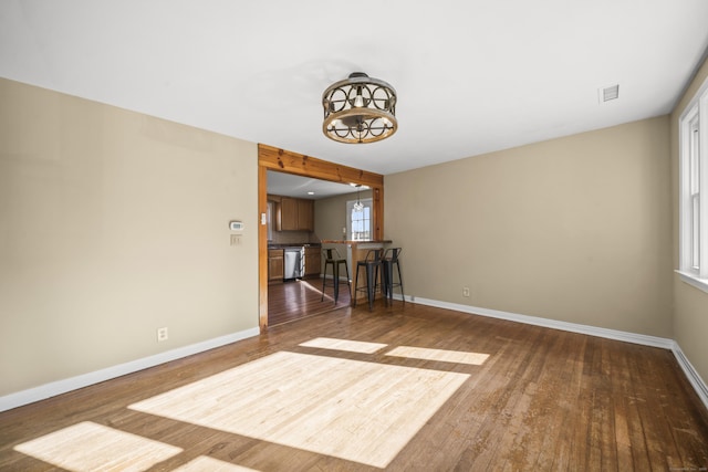 unfurnished room featuring visible vents, baseboards, and dark wood-type flooring