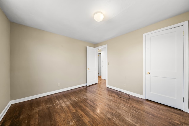 unfurnished bedroom featuring baseboards and wood finished floors