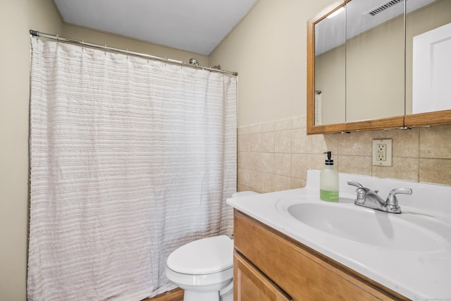 full bathroom with visible vents, toilet, vanity, a shower with curtain, and tile walls