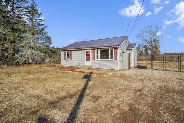 view of front of home featuring entry steps, a gate, fence, and metal roof