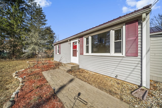 view of front facade featuring entry steps and metal roof