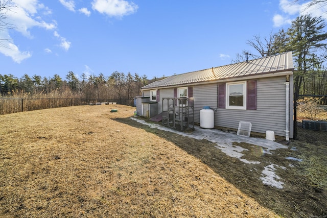 rear view of house featuring metal roof and fence