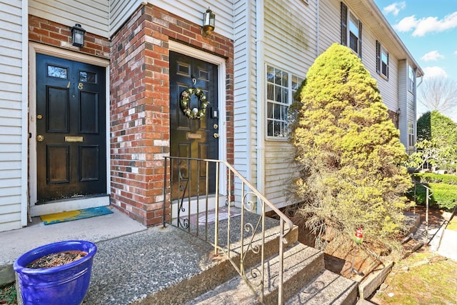 view of exterior entry with brick siding