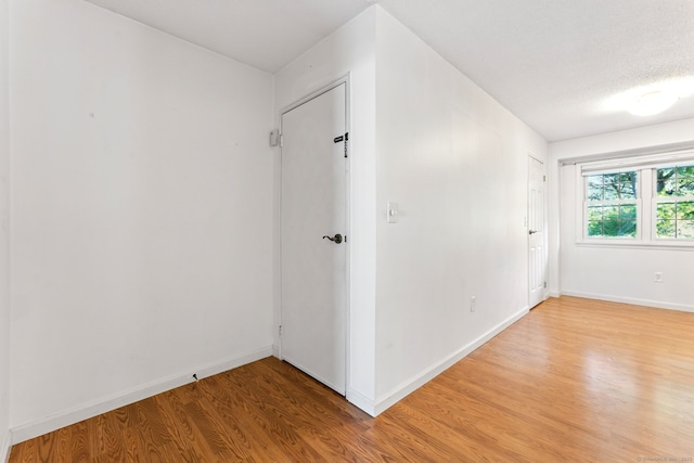 empty room featuring light wood-type flooring and baseboards