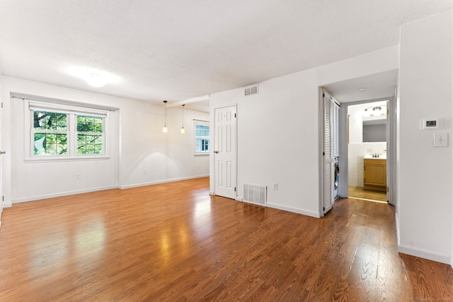 unfurnished room featuring a sink, visible vents, baseboards, and light wood finished floors