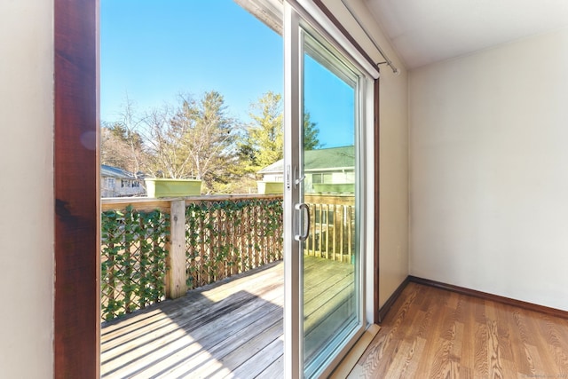 doorway featuring baseboards and wood finished floors