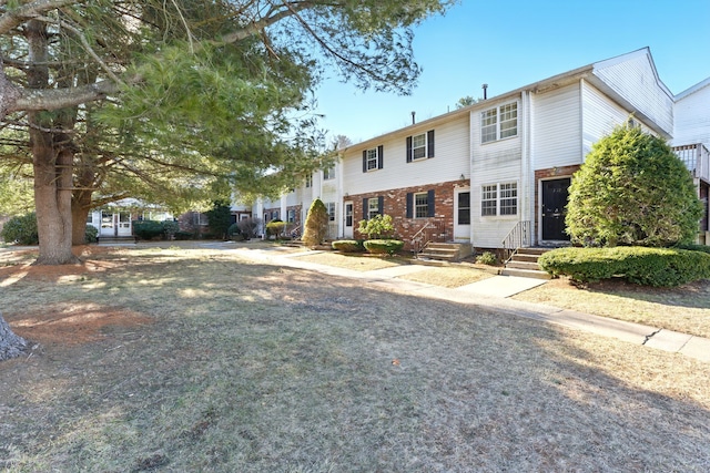 view of front facade featuring brick siding and entry steps