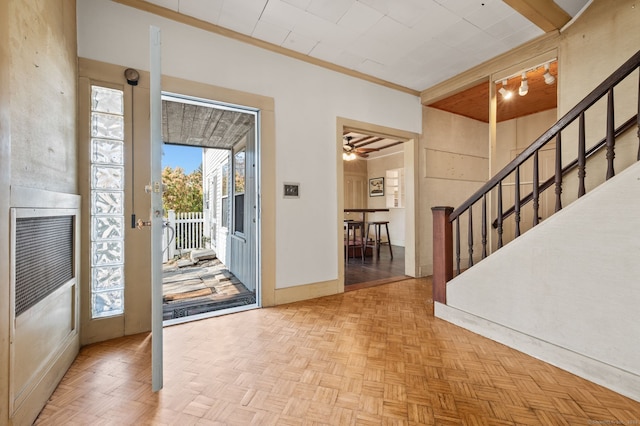 foyer entrance featuring stairway, baseboards, and a ceiling fan