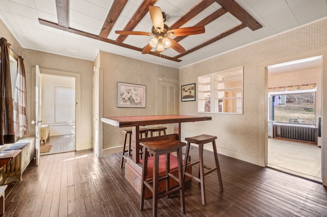 dining room featuring baseboards, wallpapered walls, dark wood finished floors, radiator heating unit, and ceiling fan