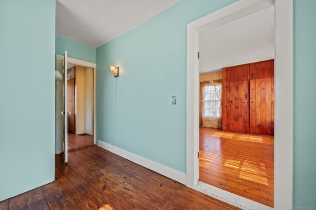 unfurnished room with baseboards and hardwood / wood-style floors
