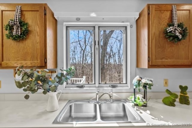 kitchen featuring a sink, brown cabinetry, and light countertops