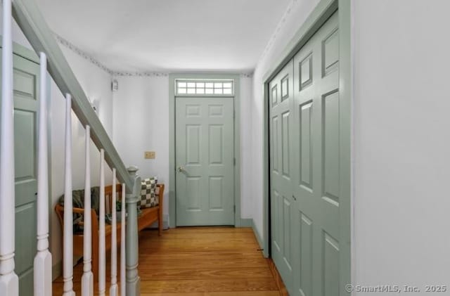 entrance foyer featuring stairway and light wood-style flooring